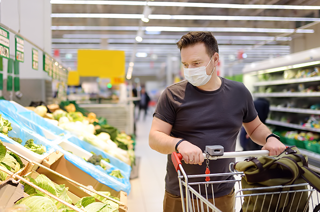 Homem fazendo comprar protegido no supermercado